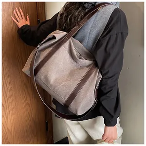 Bolso tote de lona de gran capacidad con correa marrón mostrado en un entorno cotidiano