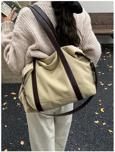 Amplio bolso tote de lona beige con correas marrón oscuro ideal para viajes o uso diario