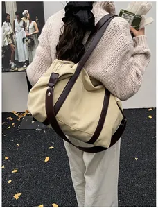 Bolso tote de lona beige de gran capacidad con correas de cuero marrón en un modelo