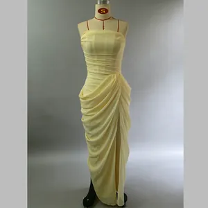 Detail view of pale yellow strapless gown with asymmetrical draping and high slit