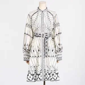 Front view of an elegant black and white geometric print dress with a matching waist belt