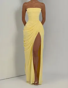 Elegant detail of yellow strapless evening gown with asymmetric pleats and sexy high slit
