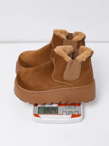 A detailed view showing women's brown platform snow boots on a digital weight scale.