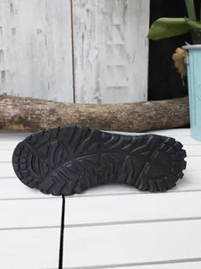 Vue détaillée de la semelle extérieure en caoutchouc noir avec crampons profonds