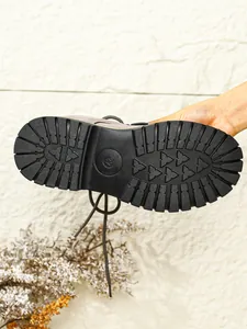 Detailaufnahme der rutschfesten Profilsohle eines grauen Wildleder-Winterstiefels
