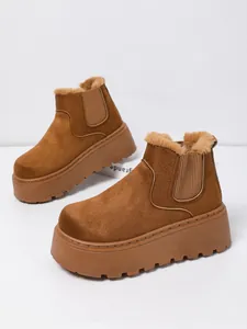Close-up of brown suede snow boots with thick platform sole and warm fur lining