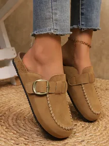 Vintage tan faux suede clogs with buckle and braided stitching detail on feet