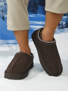 Pantuflas de nieve marrones para hombre con forro de piel sintética en un fondo nevado
