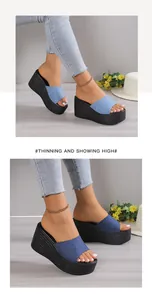 Detailed view of women's blue denim wedge slide sandals with platform sole
