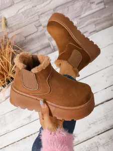 Detail of brown suede platform snow boots featuring warm faux fur lining and thick sole