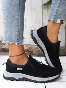 Vue détaillée de baskets de sport noires confortables avec semelles grises épaisses sur modèle.