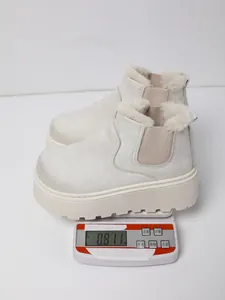A pair of off-white platform snow boots with faux fur lining weighing 0.811kg on scale