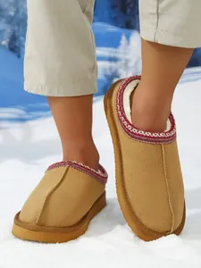 Detalle de pantuflas de gamuza camel para hombre con forro cálido y bordado étnico