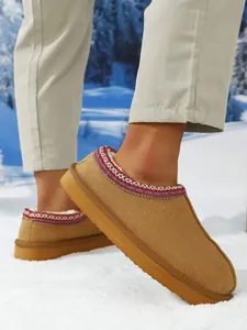 Vista detallada de botas de nieve color camel cálido con forro polar y borde bordado
