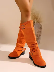 Detailansicht orangefarbener Wildleder-Slouch-Stiefel mit stilvollen Silberschnallen