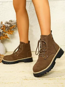 Detailansicht von stilvollen braunen Wildleder-Stiefeletten mit dicken Plateausohlen.