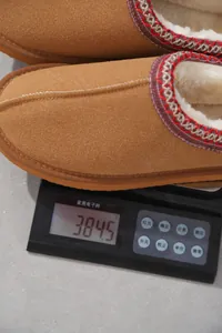 Medición del peso de un zapato de ante marrón con forro de felpa en una báscula digital
