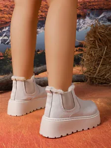 Close-up view of women's platform snow boots with warm fur lining and suede finish