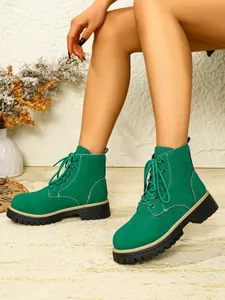 Detailansicht grüner Wildleder-Schnürstiefeletten mit dicken Profilsohlen am Model