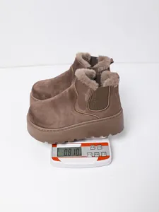 Close-up showing a pair of brown platform snow boots on a scale weighing 0.810 kg