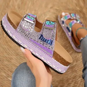Detailed close-up of purple platform sandals featuring rhinestone buckles and cork sole