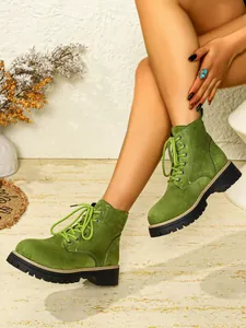 Detailansicht stilvoller grüner Wildleder-Schnürstiefel mit dicker schwarzer Plateausohle.