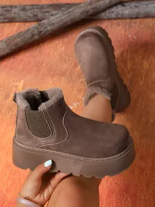 Detailed side view of women's warm brown platform suede snow boots with soft faux fur lining