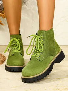 Detailansicht grüner Wildleder-Schnürstiefel mit dicker Plateausohle im Martin-Stil