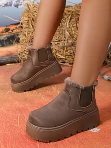 Detail view of brown suede platform Chelsea snow boots with warm faux fur lining