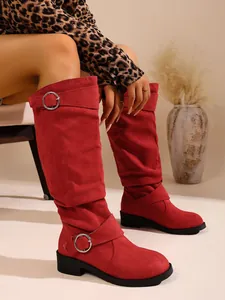 Detailansicht der roten Wildleder-Stiefel mit silbernen Schnallen und runder Zehenpartie