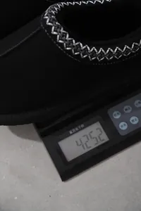 Detalle que muestra el peso exacto de una bota de nieve negra en una báscula digital