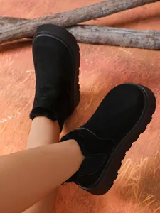 Close-up of black suede snow boots with thick soles and warm fur lining