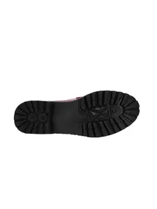 Detailed macro view of the rugged non-slip black outsole of stylish patent leather loafers