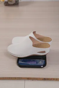 Close-up of lightweight white platform wedge mules on a scale for women's summer wear.