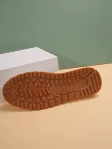 Detailed view of the durable brown rubber outsole with anti-slip tread pattern