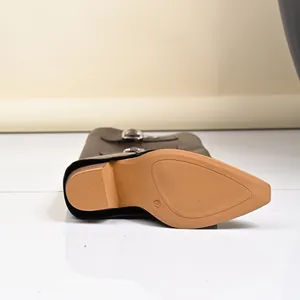 Detailed view of the tan textured sole and block heel of a vintage black Western boot
