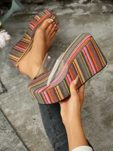 Close-up of colorful striped wedge sandals with transparent strap and platform sole