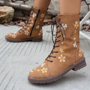 Brown lace-up mid-calf boots featuring intricate floral embroidery and low block heels.