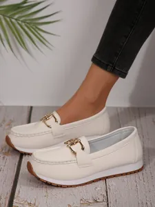 Detailed view of white platform loafers for women with elegant gold chain buckle decoration