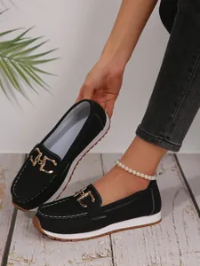 Black chunky loafer sneakers featuring a gold metal chain buckle detail