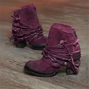 Vintage purple suede ankle boots with strap details and chunky heels on wooden floor