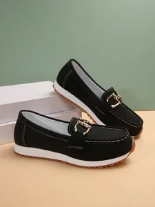 Detailed side view of black women's loafers with gold chain and thick white sole