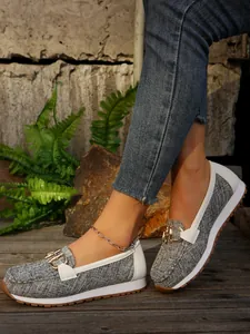 Side view of women's gray woven loafers with gold buckle and white platform sole.