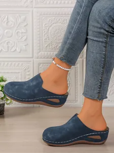 Blue wedge mules for women, closed toe platform clogs shown on feet with casual jeans.