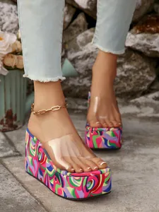 Close-up of colorful swirl pattern platform sandals with transparent PVC strap