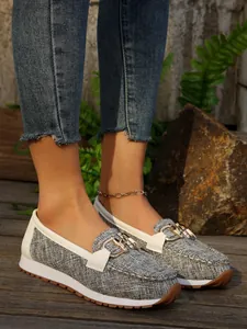Close-up of women's grey textured loafers featuring golden metal chain and platform sole