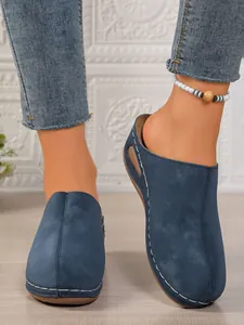 Blue closed-toe wedge mules with decorative white hand-stitching detail for women
