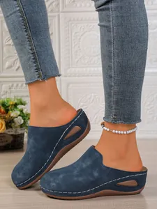 Detailed shot of women's navy blue wedge platform mules with white decorative stitching