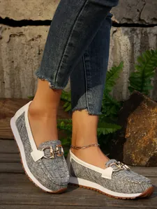 Stylish grey canvas platform loafers with gold metal chain detail on model's feet