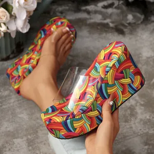 Vibrant rainbow wedge sandals with transparent PVC straps and high platform.